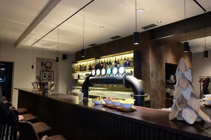 Il bancone del Sada Bar con le spine della birra e le bottiglie illuminate