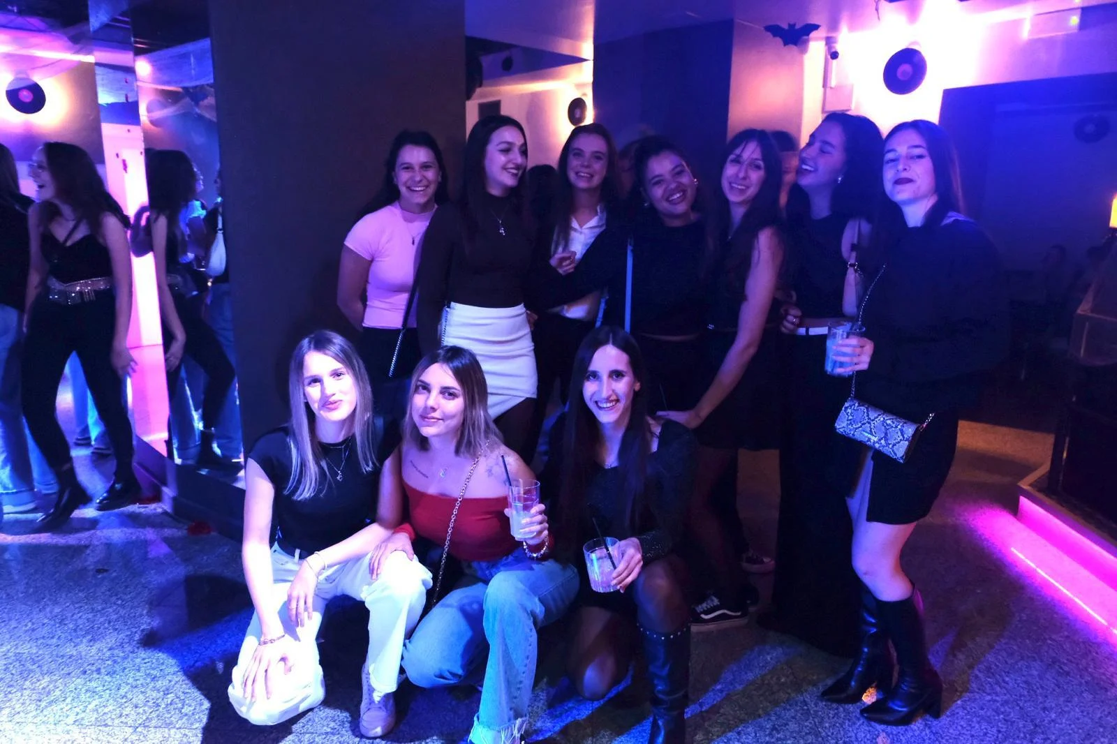 Gruppo di amiche in posa sotto le luci viola della pista